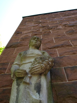 Bild: Die linke Figur am Tor der Mahnung verkörpert die trauernde Mutter oder Ehefrau - aber aufrecht und sich in das Unvermeidliche fügend.