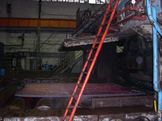 Bild: Das Breite Umkehr-Walzwerk. Walzen von Kupfer-Nickel-Blechen. Das Blech wurde mit Hilfe von Wasser vom Zunder befreit. Letzte Wassertropfen perlen vom noch glühenden Blech.