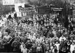 Bild: Sympathisanten der Kommunistischen Partei Deutschlands mit ihren Kindern vor der Ludwig-Jahn-Turnhalle in Eisleben. Dieses Bild ist gemeinfrei, weil seine urheberrechtliche Schutzfrist abgelaufen ist.